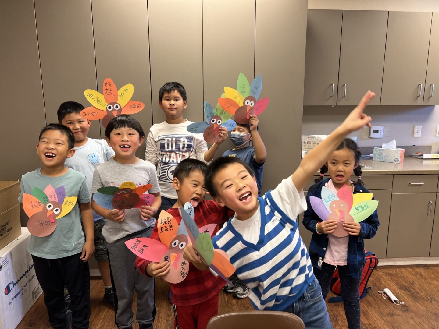 Children holding colorful turkey crafts, smiling.