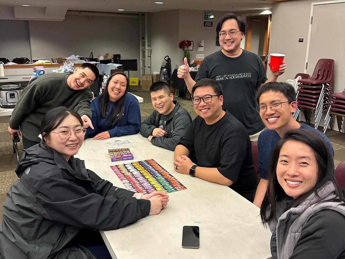 A group of friends enjoying a board game around a table, smiling and having fun.